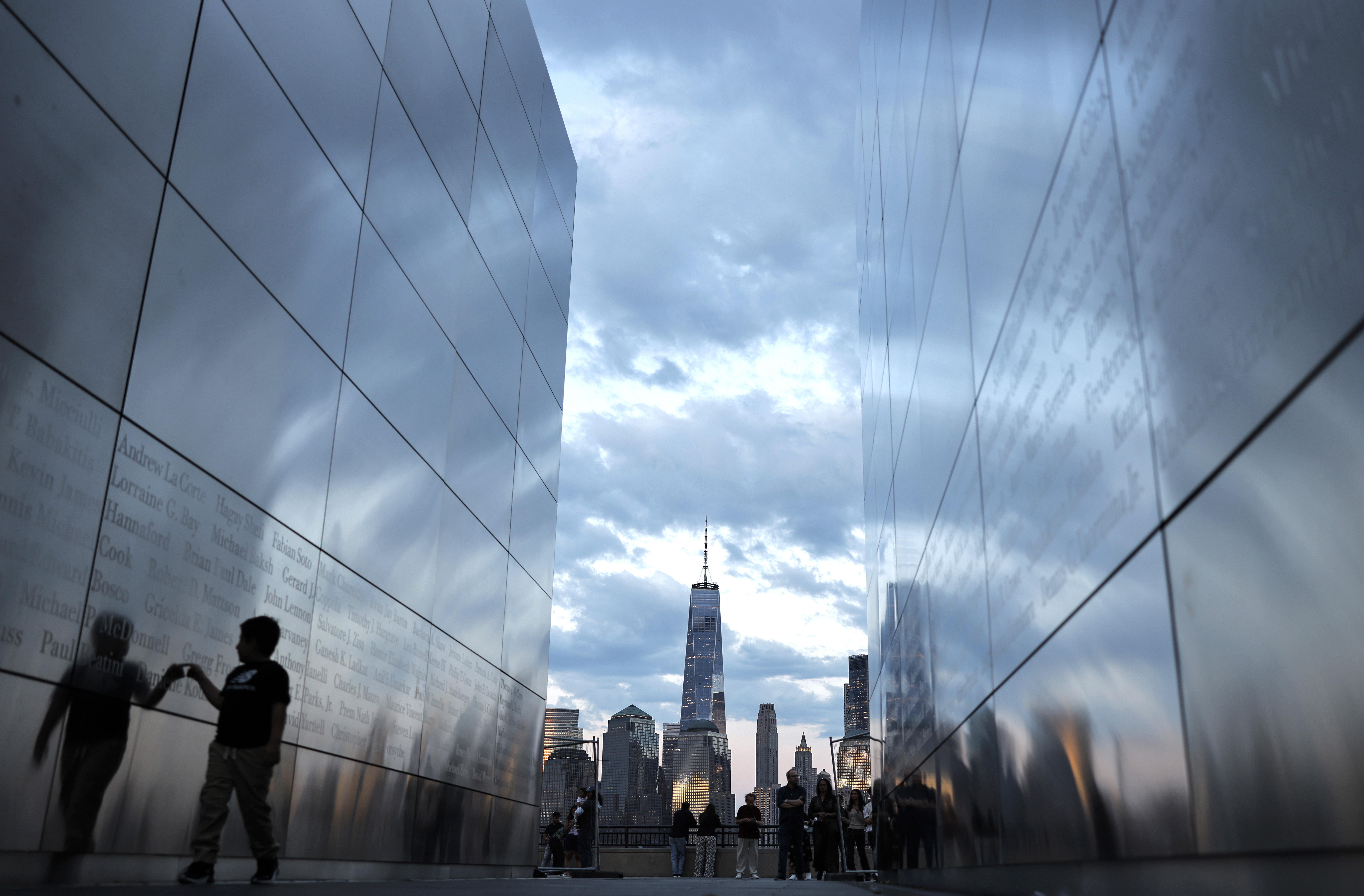 A child walks through Empty Sky, the 9/11 memorial in Jersey City, N.J., on Aug. 23. In the distance are One World Trade Center and Lower Manhattan.